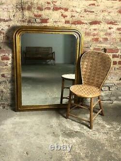 Glace / miroir de style Louis Philippe en bois doré patiné bronze 121 x 95 cm